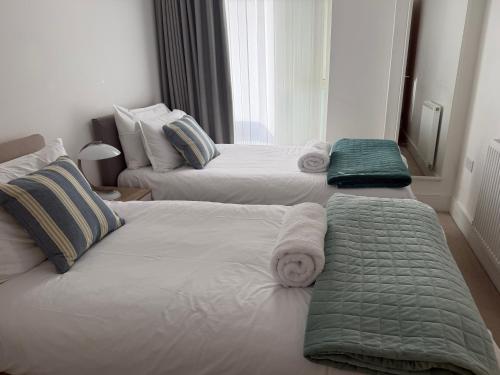 a bedroom with two beds with towels on them at Seaview West Coast - Exceptional - 2 Bedrooms Sleeps 5 -Stunning Sea Views - 500 metres to Beach in Bournemouth