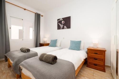two twin beds in a room with a window at Villa Beso in San Antonio