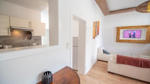 a white living room with a couch and a table at Ferienhaus zum Brauneberg in Klotten