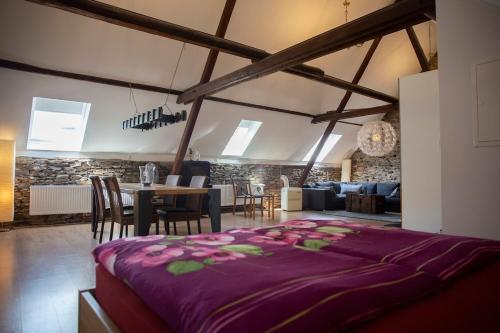 a room with a large bed and a dining room at Ferienhaus zum Brauneberg in Klotten