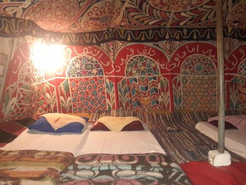 a bedroom with a bed in a room with a patterned wall at Energy camp in Bawati