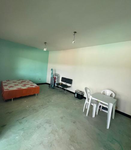 a room with a bed and a table and chairs at Mansão Xodó in Marataizes