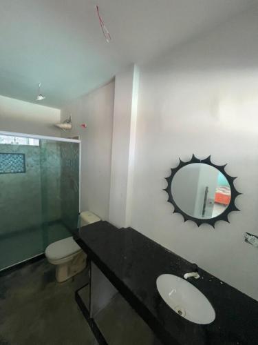 a bathroom with a sink and a mirror on the wall at Mansão Xodó in Marataizes