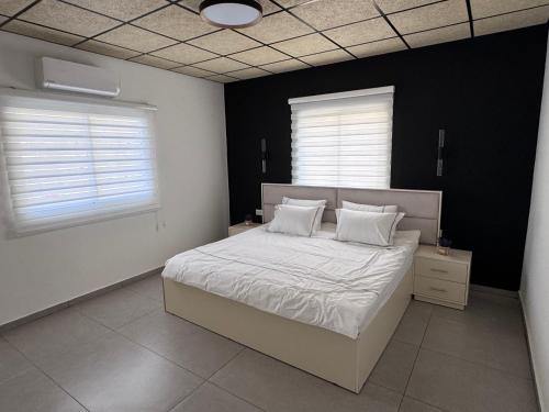 a bedroom with a bed with white sheets and white pillows at Country breeze park in Majdal Shams
