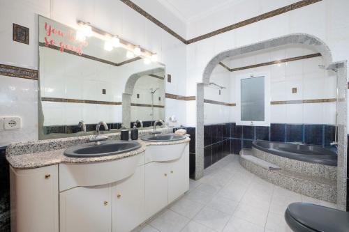 a large bathroom with two sinks and a tub at Villa Sunset - San Antonio Bay in Cala de Bou
