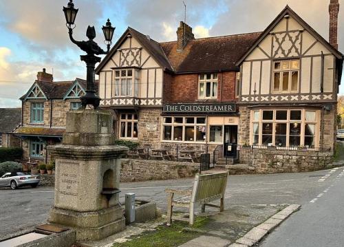a building with a bench in front of a street at The Coldstreamer Inn in Penzance