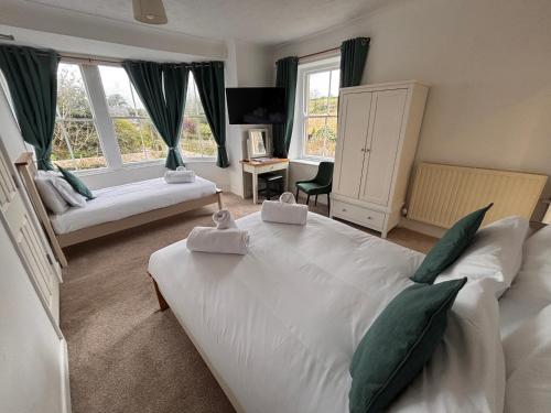 a bedroom with a large white bed and a couch at The Coldstreamer Inn in Penzance