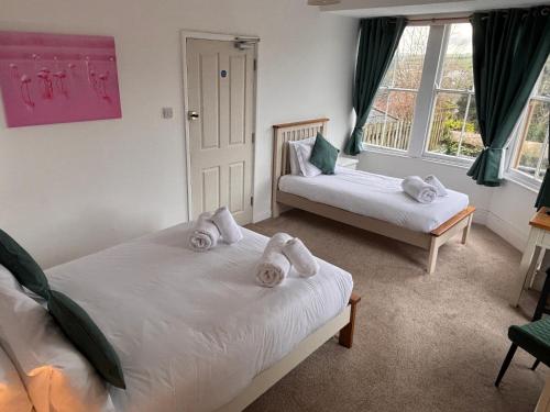 a bedroom with two beds with towels on them at The Coldstreamer Inn in Penzance