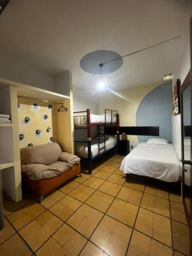 a bedroom with two bunk beds and a couch at Hotel Gandag in Orizaba