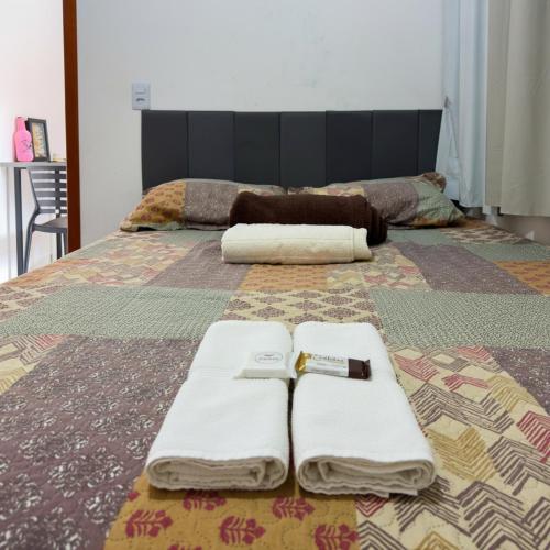 a bed with two towels and a knife on it at Flat Mobiliado no centro in Redenção