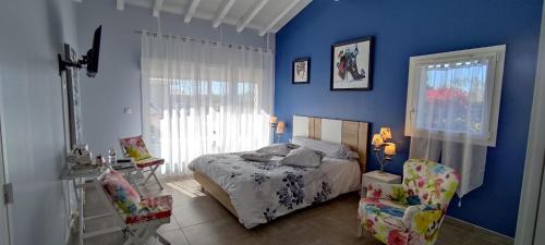 a bedroom with a bed and a blue wall at Chambres d'Hôtes Aube de Lune in Saint-Palais-sur-Mer