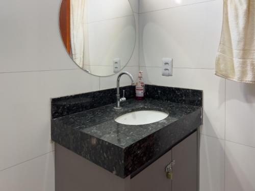 a bathroom with a sink and a mirror at Flat Mobiliado no centro in Redenção