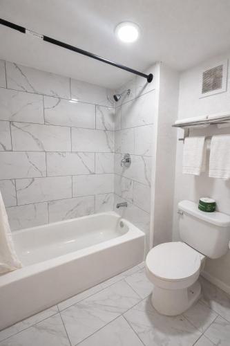 a white bathroom with a tub and a toilet at Motel 6 Sherman, TX in Sherman