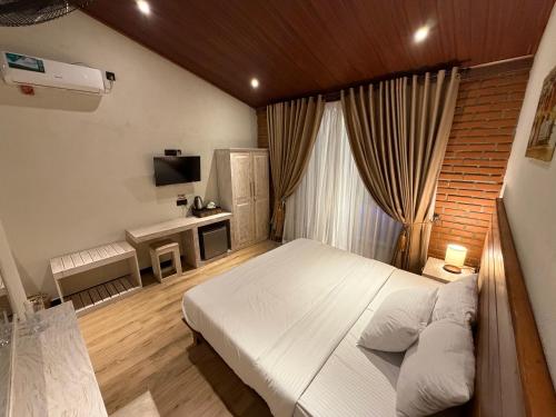 a bedroom with a white bed and a television at Sunsei Beach Negombo in Negombo