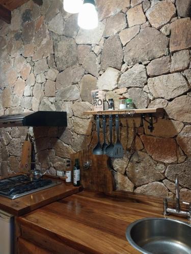 a kitchen with a stone wall with a sink and a counter at soy ahora segunda in San Javier