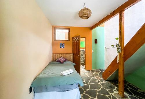 a small room with a bed and a staircase at Granja Tzikin in Tzununá