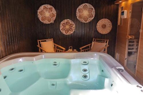 a bath tub in a room with chairs at Lila in Bet Leẖem HaGelilit