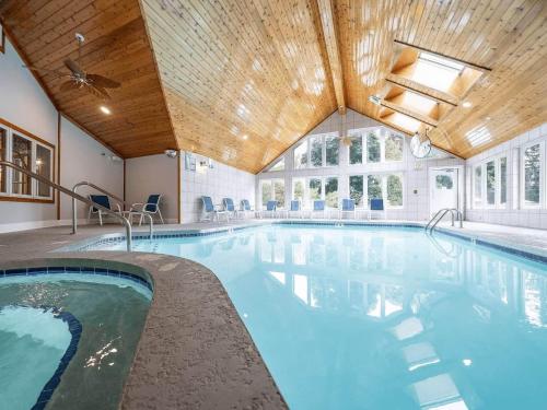 a swimming pool in a building with a wooden ceiling at Waterbury Inn in Ephraim