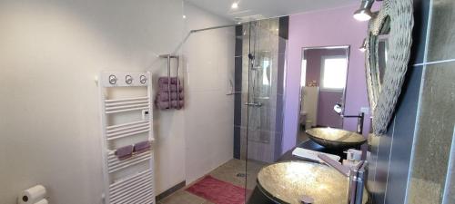 a bathroom with a sink and a glass shower at Chambres d'Hôtes Aube de Lune in Saint-Palais-sur-Mer
