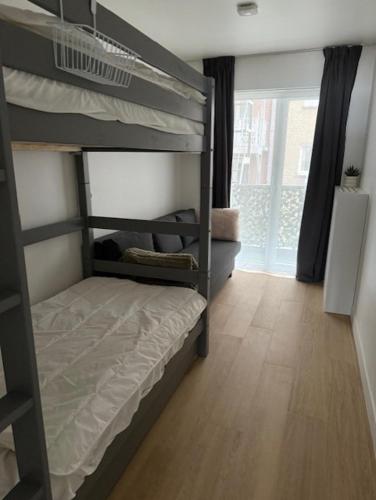 a bedroom with two bunk beds and a wooden floor at Orion NorthSea Suite in Blankenberge