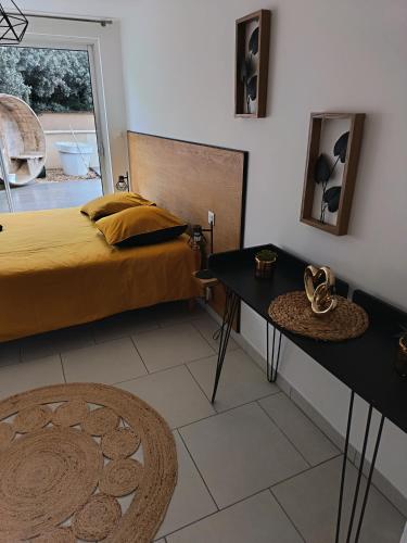 a bedroom with a bed and a table and a mirror at Gites de Lenny in Valréas