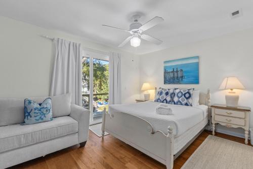 a white bedroom with a bed and a couch at The Ugly Dolphin a Stylish Home for 12 in Edisto Island