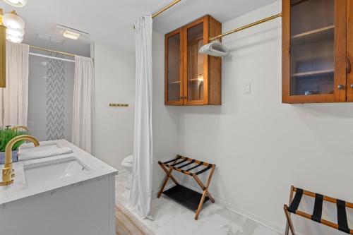 a white bathroom with a sink and a toilet at The Ugly Dolphin a Stylish Home for 12 in Edisto Island