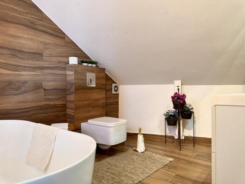 a bathroom with a white tub and a toilet at Deluxe Loft at Monteverde in Beit Meri