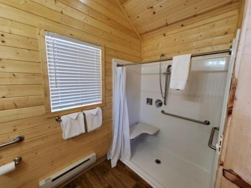 a bathroom with a shower in a wooden cabin at Sun Outdoors Arches Gateway in Moab