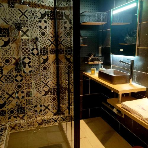 a bathroom with a sink and a shower at La Cabane Enchanteresse in Illoud
