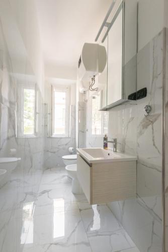 a white bathroom with a sink and a toilet at Downtown flat historic Reggio in Reggio di Calabria
