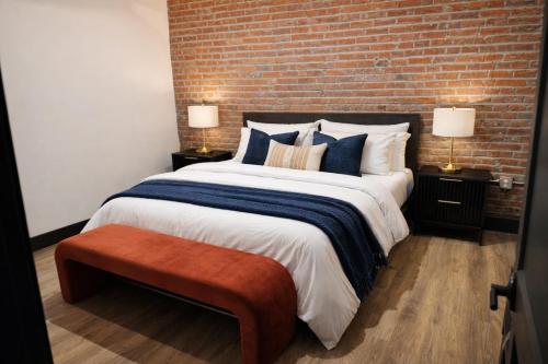 a bedroom with a large bed and a brick wall at Brick & Bed Riverfront Lofts, T 401 in Saint Louis