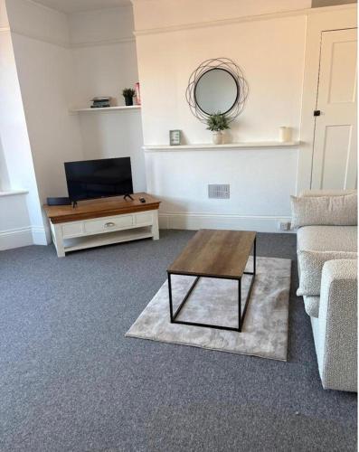a living room with a couch and a coffee table at Brand New Convenient Apartments Folkestone in Folkestone
