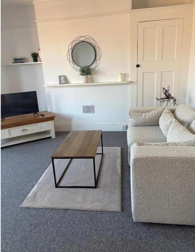 a living room with a couch and a coffee table at Brand New Convenient Apartments Folkestone in Folkestone