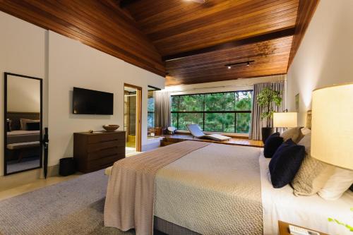 a bedroom with a large bed and a large window at Sítio dos Lagos in Domingos Martins