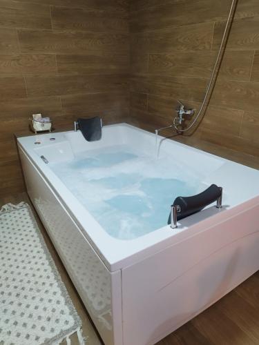 a white bath tub with a faucet in a bathroom at Drina in Pale