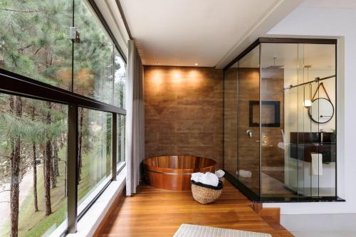 a bathroom with a tub and a large window at Sítio dos Lagos in Domingos Martins