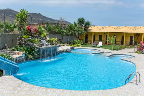 a pool with a waterfall in a yard at Tuzco Lodge in Puerto López