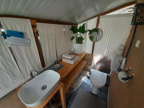 a bathroom with a white sink and a toilet at A tiny sea home in the wilderness in Vis