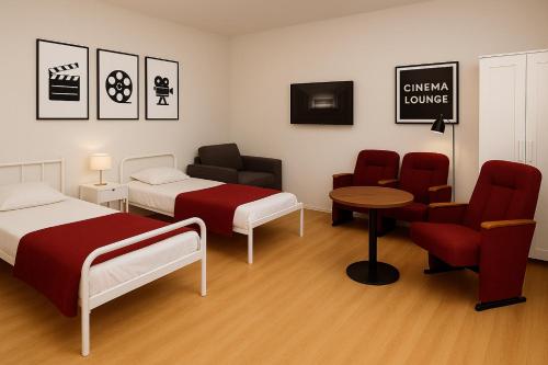 a room with two beds and a table and chairs at City Quartier Wedel in Wedel