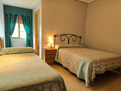 a bedroom with two beds and a window at Hotel La Moraleda - Complejo Las Delicias in Villanueva del Arzobispo