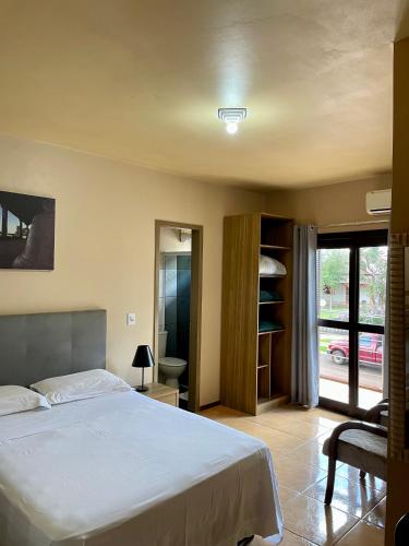 a bedroom with a bed and a view of a street at Hotel Barichello in São Miguel das Missões