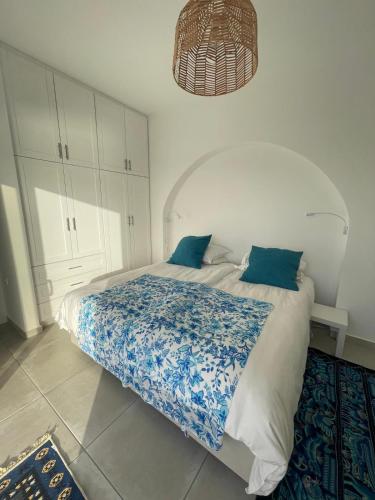 a bedroom with a large bed with blue and white sheets at Shaunagh's Place in Kalymnos