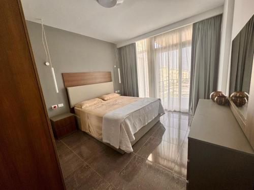 a bedroom with a bed and a large window at Sharm Sea View - Sunny Beach in Sharm El Sheikh