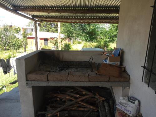 an outdoor brick oven with a roof over it at La Griselda in El Mollar
