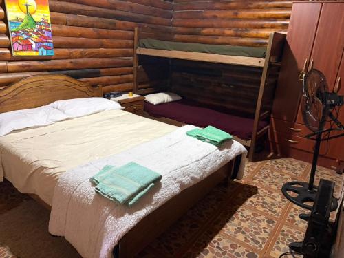 a bedroom with two beds in a log cabin at Campo Los Teritos in Abasto