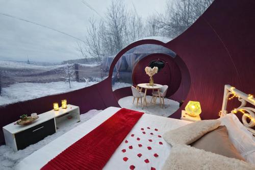 a tent with a bed and a table in the snow at La Bulle Des Anges in Illoud