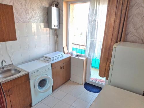 a small kitchen with a washing machine and a window at APARTAMENTS Verkvebi in Gori