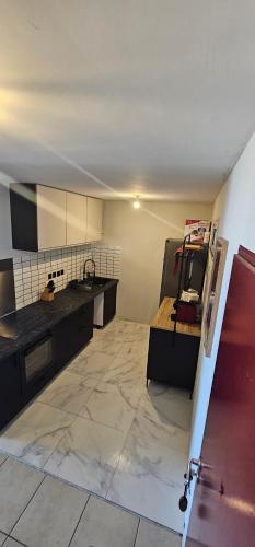a large kitchen with a sink and a counter at KAZ Les pêchers in Saint-Denis