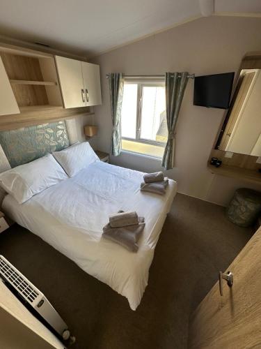 a bedroom with a large bed with towels on it at Dolphin View in Llanddwywe